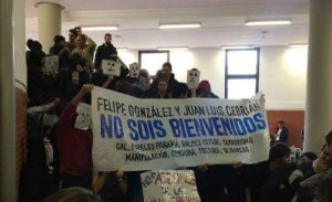 "Фелипе Гонсалес и Хуан Луис Себриан, НЕ СТЕ ДОБРЕ ДОШЛИ", пише на плаката, разпънат от протестиращите пред аулата в Автономния университет на Мадрид