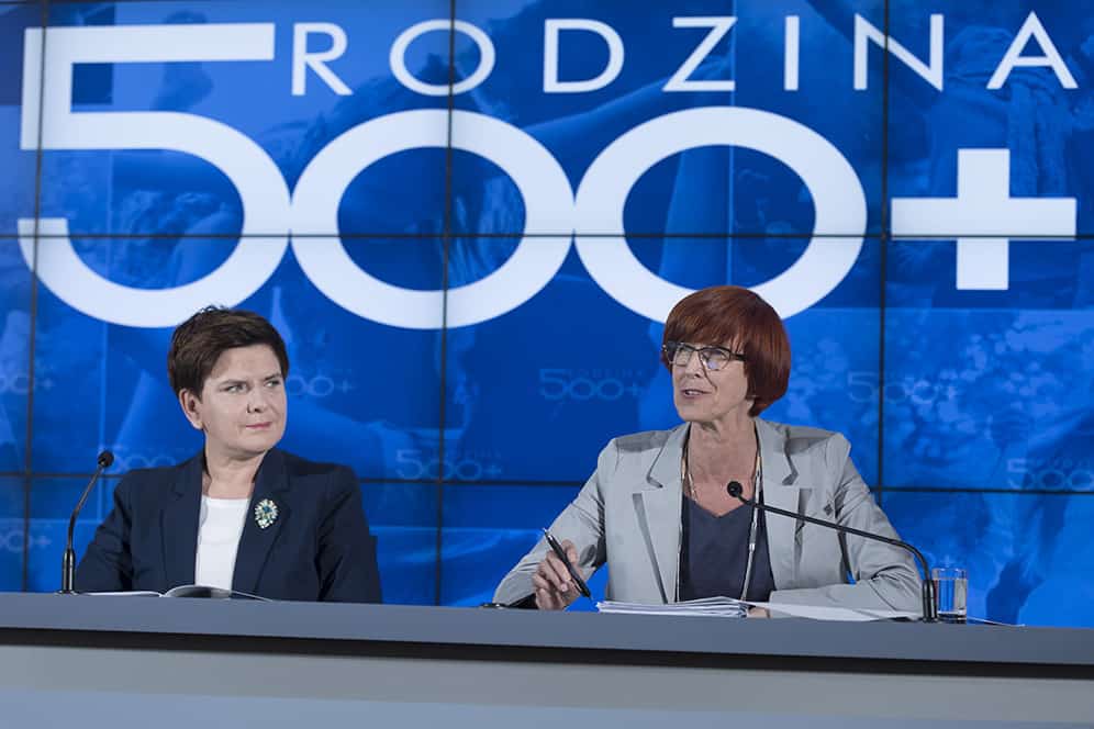 Беата Шидло (вляво) и Елжбиета Рафалкска (министър на труда и социалната политика) по време на първата пресконференция след въвеждането на програмата "500+". Източник: Уикимедия Комънс (Wikimedia commons)