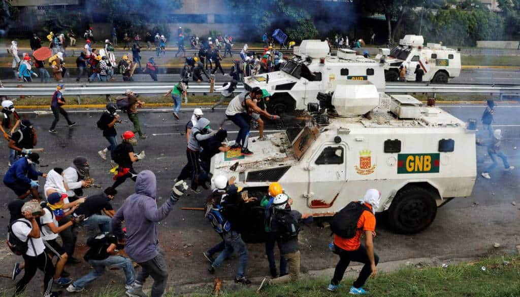 "Мирни" демонстранти по улиците на Каракас атакуват блиндирани коли на жандармерията. Препечатка от El Pais