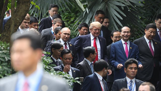 Путин и Тръмп разговарят "на крак", до тях сияе усмихнат виетнамският президент Чан Дай Куанг, а от другата му страна е китайскиет лидер Си Цзинпин
