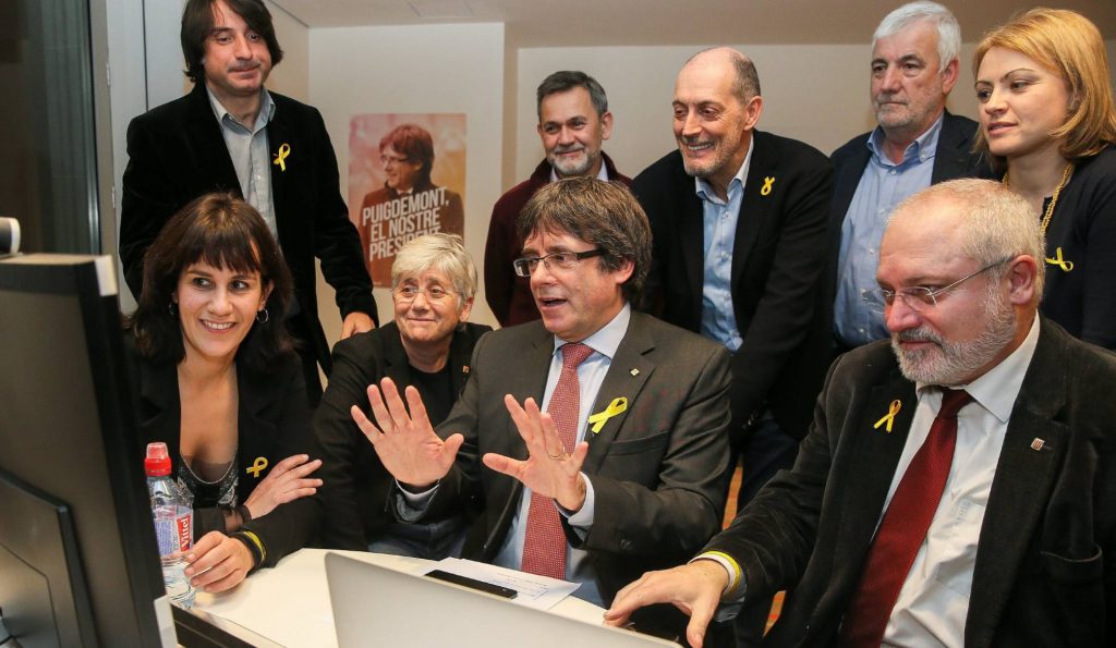 Карлес Пучдемон (в средата), заобиколен от свои бивши министри, някои от които бяха избрани и за депутати. Трима от тях се отказаха от депутатските си кресла и отстъпиха място на следващите в списъка, за да улеснят събирането на необходимото мнозинство от гласове в каталунския парламент. Снимка: EFE