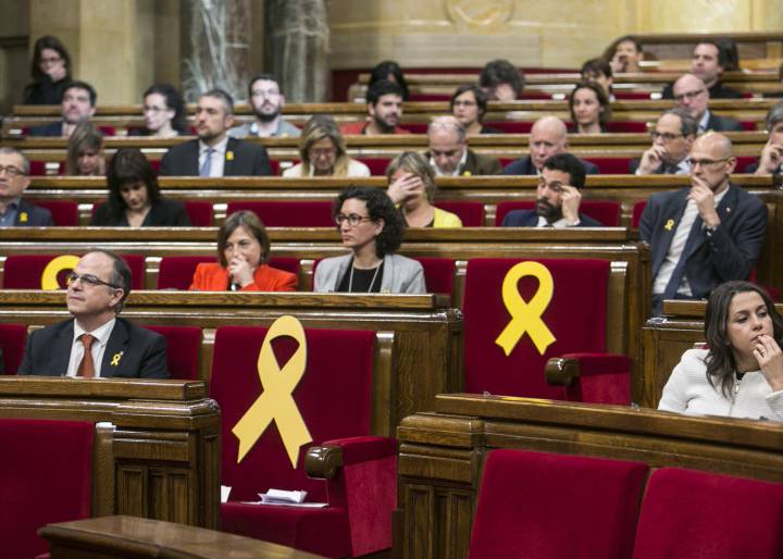 Празните места на осемте сепаратистки депутати, които са или в затвора, или в Брюксел, демонстративно са отбелязани с жълти панделки в новия каталунски парламент. Снимка: EFE 