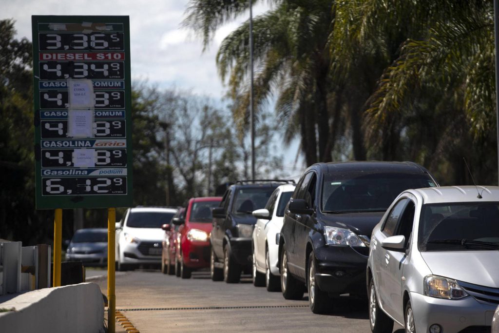 Опашка от коли край бензиностанция, която е обявила, че затваря заради липса на зареждане. На таблото личат цените на горивата в реали. Снимка: EFE