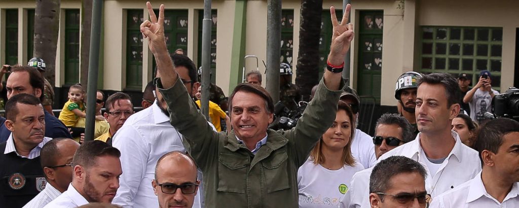 Жаир Болсонаро след като гласува на вота в неделя в Рио де Жанейро. Вдясно зад него се вижда сегашната му трета съпруга Мишел, родена през 1980 г. Снимка: Folha de Sao Paulo