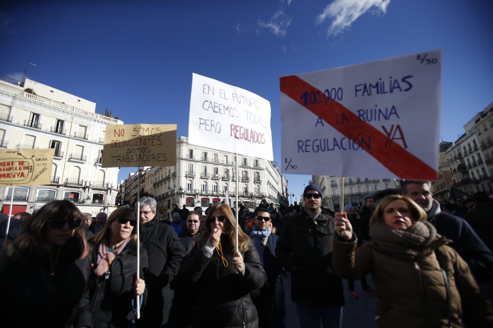 Участници в стачката издигнаха на мадридския площад "Пуерта дел Сол" плакати, които алармират, че нелоялната конкуренция тласка 100 000 семейства на работещи в таксиметровия превоз към разорение. Снимка: El Pais