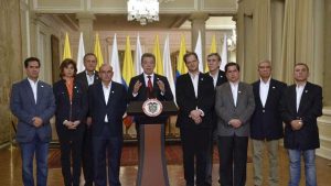 Президентът Хуан Мануел Сантос (в центъра) по време на обръщението си, заобиколен от своя екип в мирните преговори