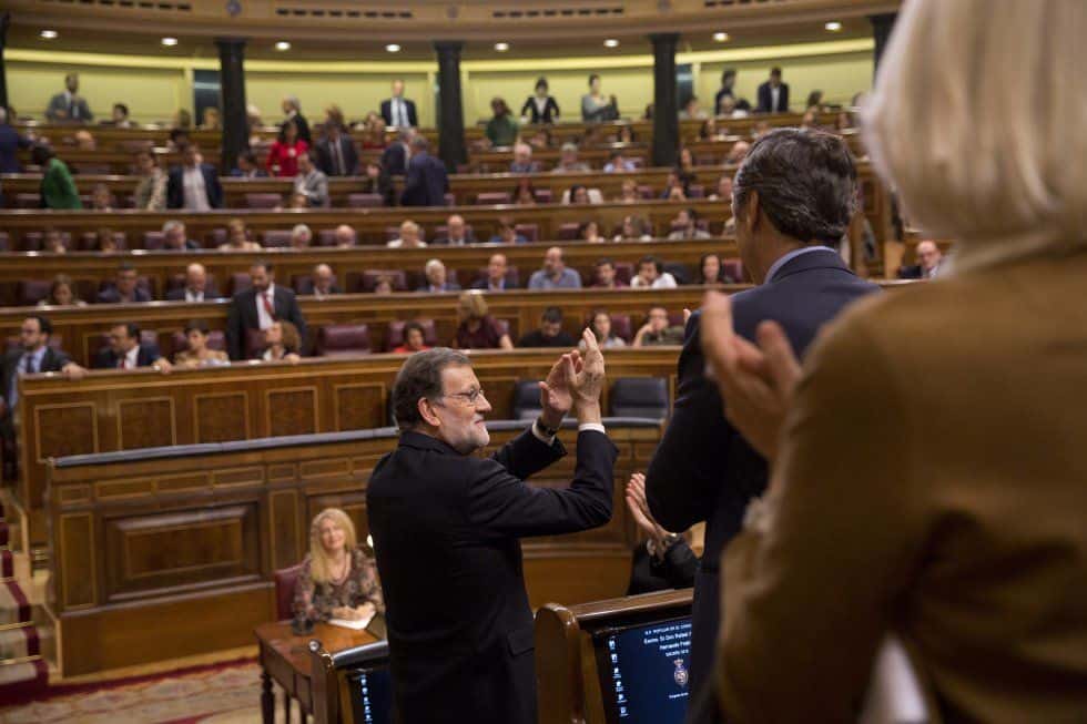 Мариано Рахой приема овациите на съпартийците си след одобряването му за премиер