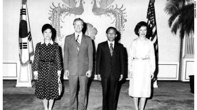 Като младо момиче Пак Кън Хе играе ролята на първа дама по време на управлението на баща си Пак Чжон Хи. Тук тя посреща заедно с него в Сеул през 1979 г. президента на САЩ Джими Картър и съпругата му