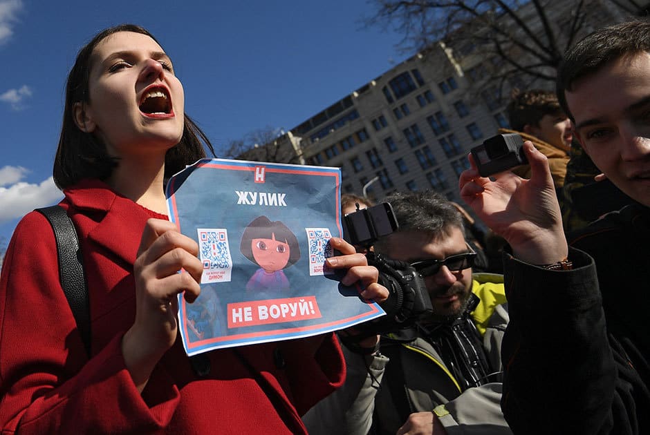 Млада учасничка в протестите носи плакат срещу корупцията. Снимка: РИА