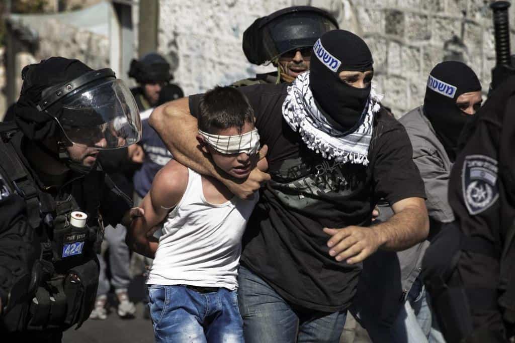 Израелски полицай арестува палестинско дете. Снимка: addameer.org