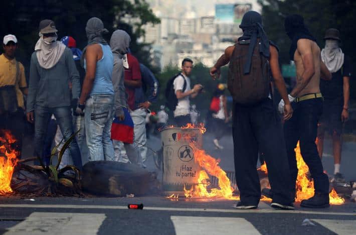 Маскирани "демонстранти" край направено от тях заграждение на кръстовище в Каракас. Снимка: albaciudad.org