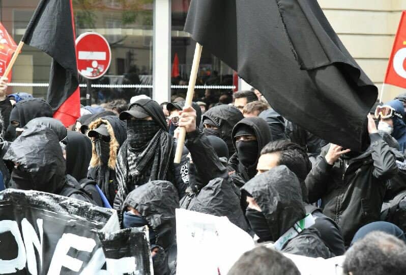 В първомайските прояви в париж се включиха и маскирани участници в черно, част от които предизвикаха сблъсъци с полицията. Снимка: Prefecture de Police de Paris