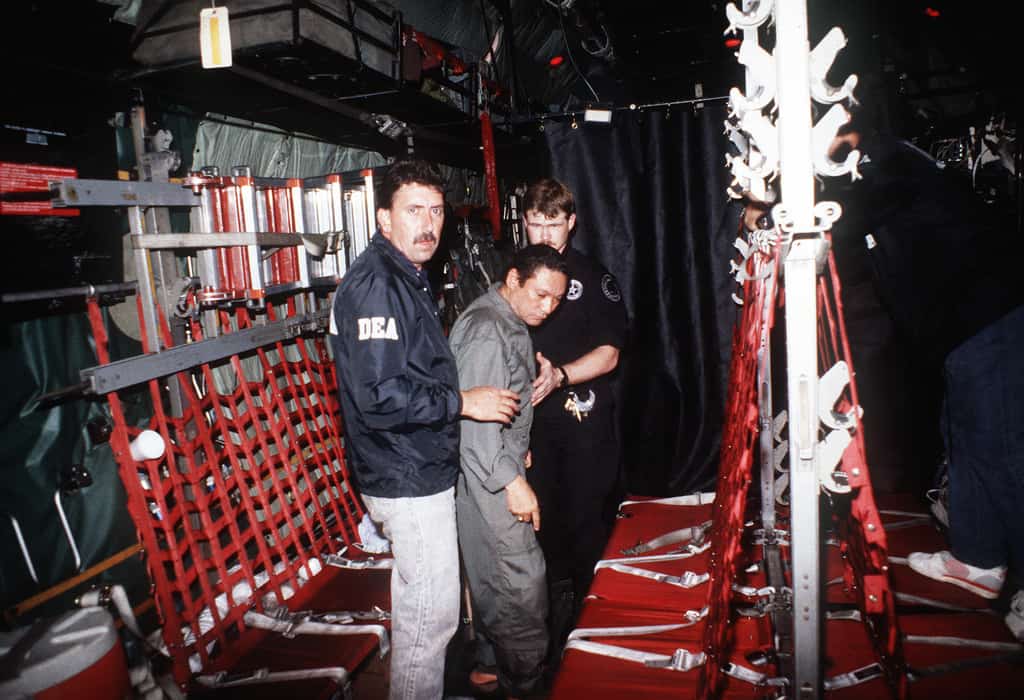 Мануел Антонио Нориега с агенти на DEA след ареста му в началото на 1990-та. Снимка: Уикипедия