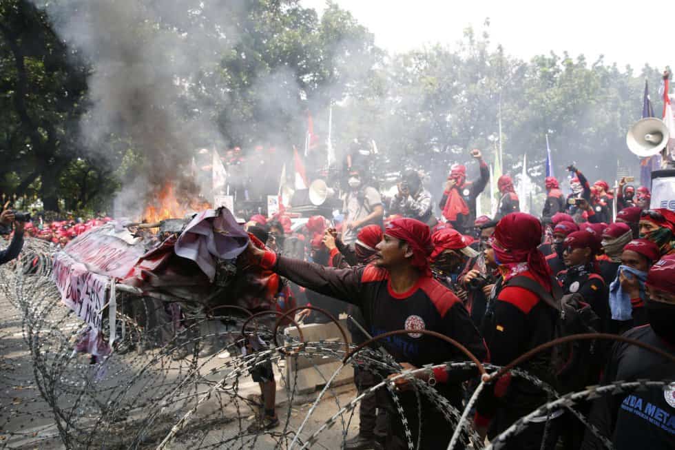 Индонезийски работници подпалиха протестно плакатите на първомайското си шествие, след като полицията в Джакарта ги възпря с улични прегради. Снимка: ЕФЕ