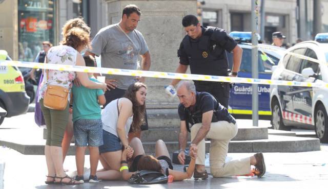 Хора се опитват да помогнат на жена, пострадала при нападението на "Рамблас". Снимка: El Pais