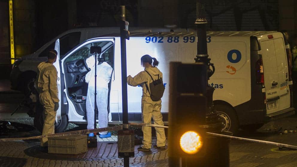 Полицаи изследват микробуса убиец от "Лас Рамблас", който е спрял, защото автоматичната аварийна система след многото удари в хора е надула въздушната възглавница и е блокирала електроподаването към двигателя. Снимка: La Vanguardia