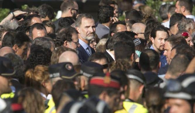 В центъра на тази снимка е погледналият към камерата крал Фелипе. До него в профил е премиерът Мариано Рахой. в Дясната част на кадъра пак с лице към камерата е лидерът на "подемос" Пабло Иглесиас. Снимка: EFE