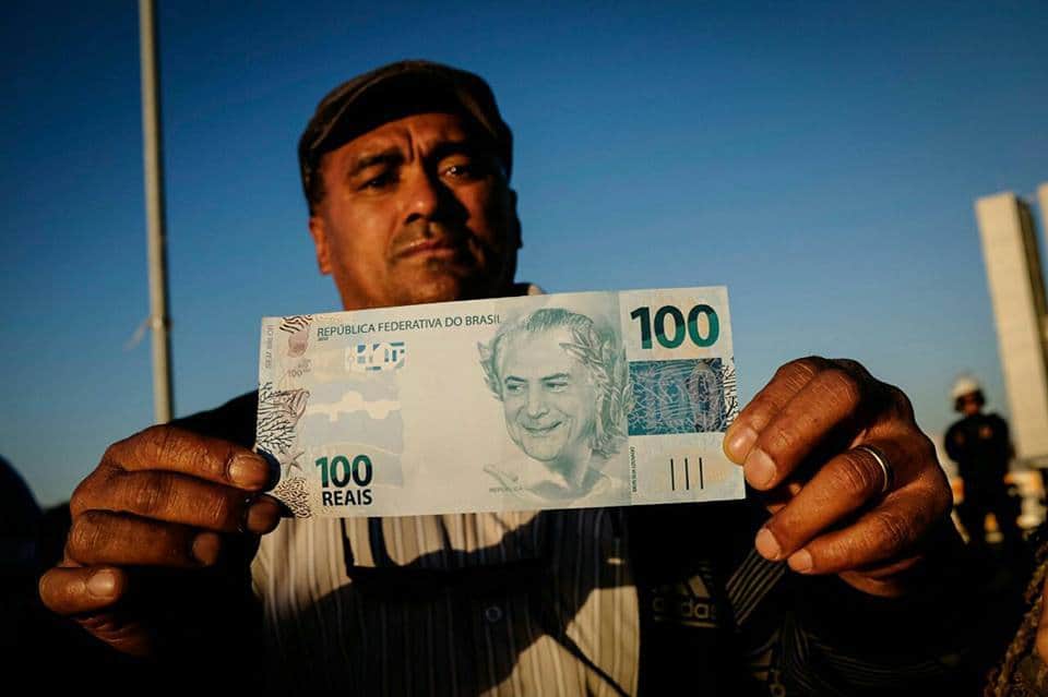 Още един протестиращ усърдно показваше на фоторепортерите фалшива банкнота с образа на Мишел Темер. Снимка: Resumen Latinoamericano