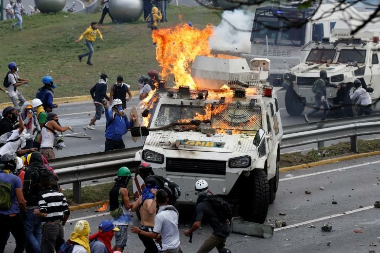 "Мирни" демонстранти атакуват полицейски джип в Каракас през юни т.г. Снимка: Resumen Latinoamericano