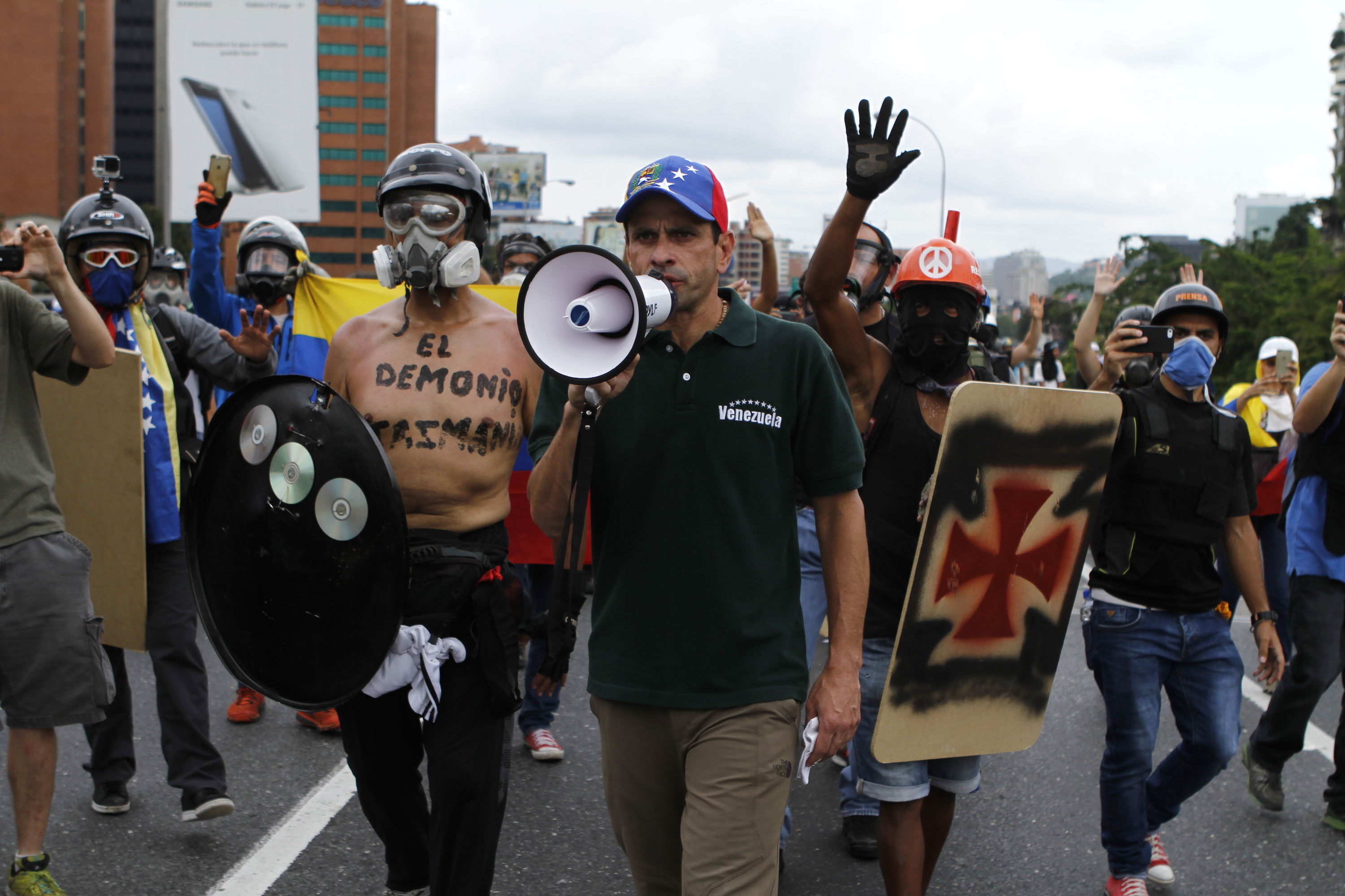 Венесуелският опозиционен водач Енрике Капролес (с мегафона) нахъсва протестиращи по време на антиправителствените безредици в Каракас през май т.г. Снимка: Resumen Latinoamericano