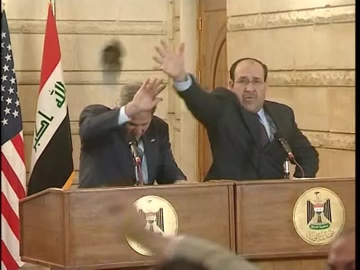 Втората обувка също полита към Буш, Ал-Малихи гледа да предпази госта си с ръка, но и самият Буш умело се пази. Снимка: Youtube