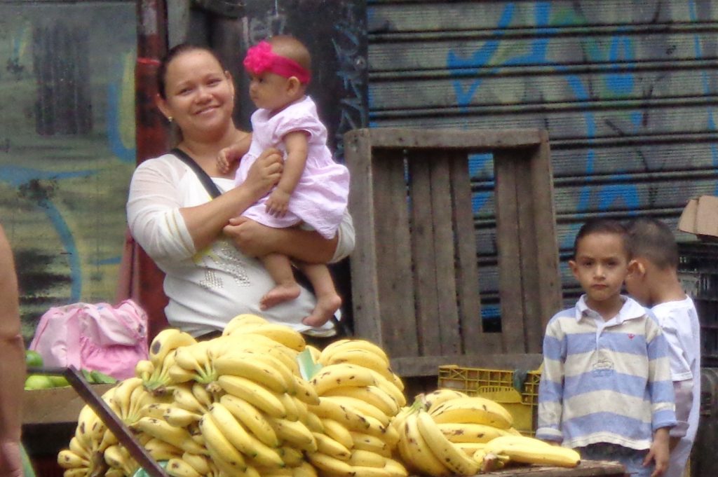 Усмивката не слиза от лицата на венесуелците. Тя е и първата комуникация с клиентите за тази млада майка и продавачка на банани в центъра на Каракас. Снимка: Къдринка Къдринова