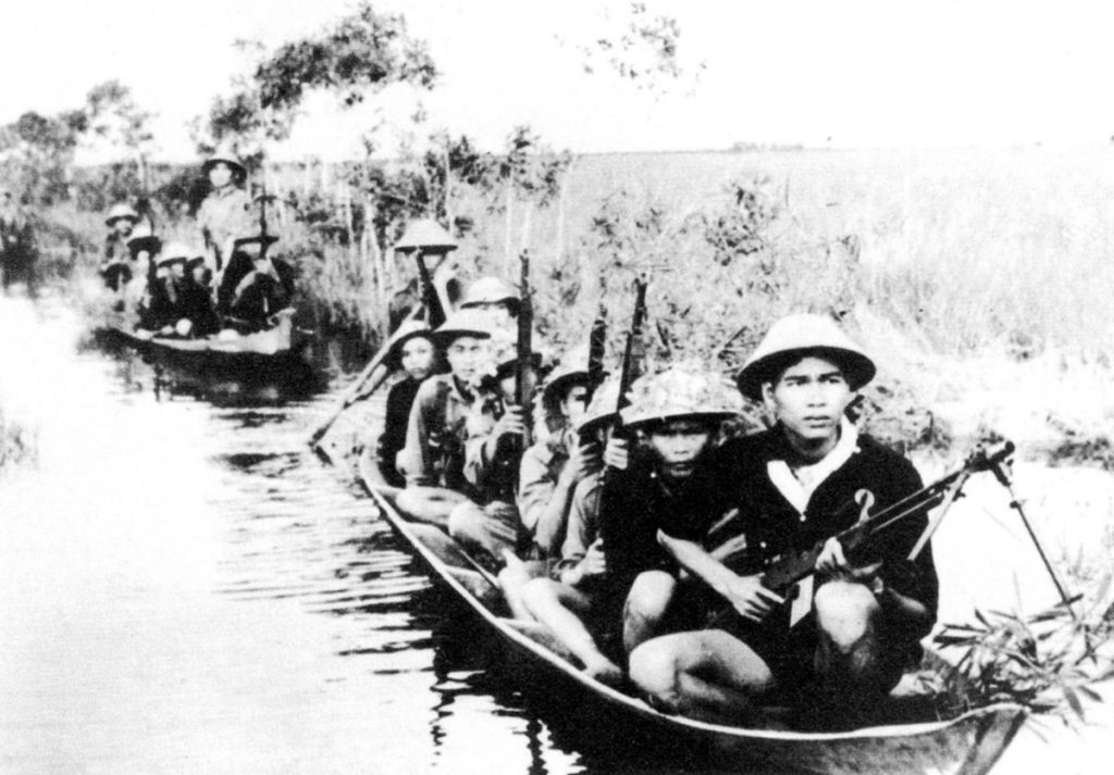 Южновиетнамски партизани се придвижват с лодки, за да атакуват противника. Снимка: VNA