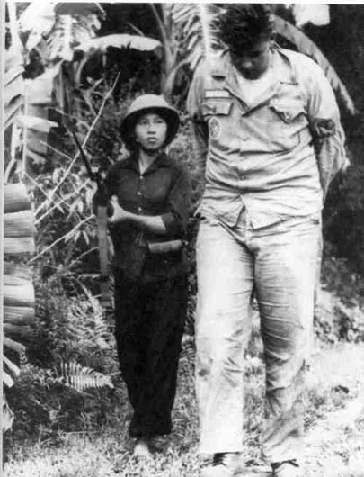 Този кадър също става исторически–дребна виетнамска партизанка води едър американски пленник. Снимка: VIA