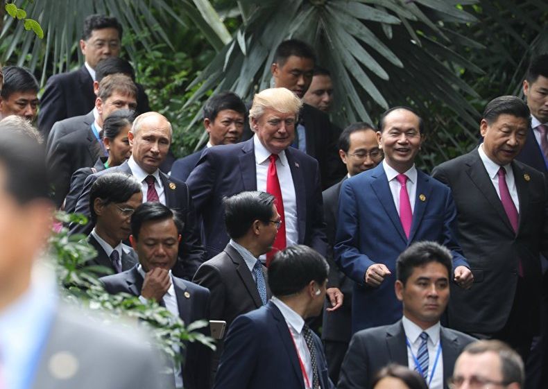 Путин и Тръмп разговарят „на крак“, до тях сияе усмихнат виетнамският президент Чан Дай Куанг, а от другата му страна е китайскиет лидер Си Дзинпин. Снимка: РИА