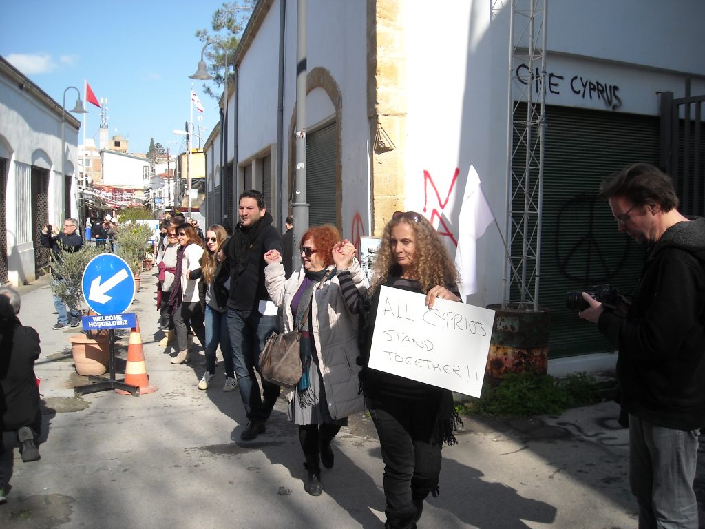Кипърски турци и кипърски гърци протестират заедно срещу атаката срещу вестник „Африка” и насилието, за мир и обединение на страната в центъра на Никозия, в буферната зона, разделяща двете части на кипърската столица–27 януари 2018 г. Снимка: архив на авторката