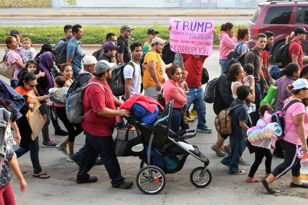 „Доналд Тръмп провокира миграцията, защото подкрепя едно корумпирано правителство”. пише на плаката, издигнат сред потока от хондураски "нашественици". Снимка: TeleSur