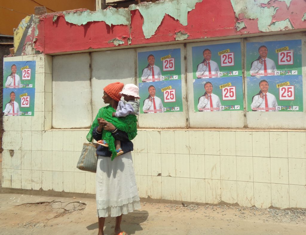 Бедна жителка на Антананариво заеднос детето си край предизборни плакати с Марк Раваломанана. Снимка: Къдринка Къдринова