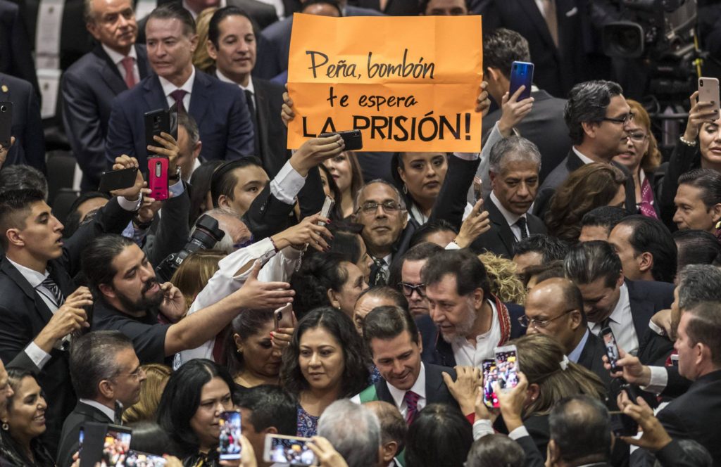 При влизането на досегашня президента Енрике Пеня Нието (в центъра на долната част на снимката) опозиционен депутат размаха плакат, на който пишеше: "Пеня, бонбоне, чака те затвор!". Снимка: El Pais