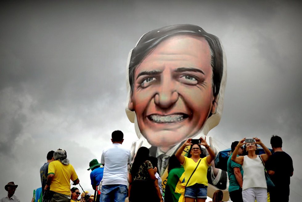 Привърженици на Болсонаро си правят селфита пред балон с неговия лик преди началото на речта му на Площада на трите власти в град Бразилия. Снимка: EFE