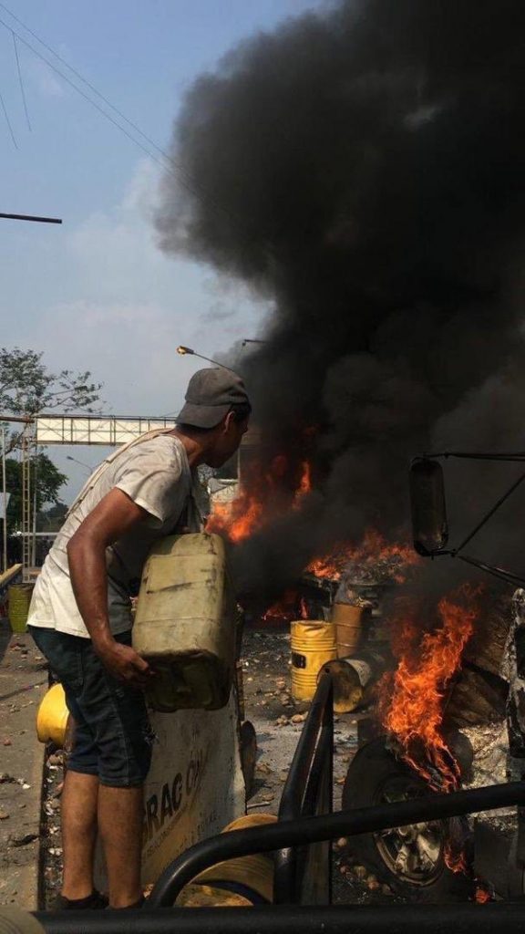 Популярна в социалните мрежи стана снимката на този демонстрант, подливащ бензин от бидон в огъня на горящия камион. Снимка: Фейсбук