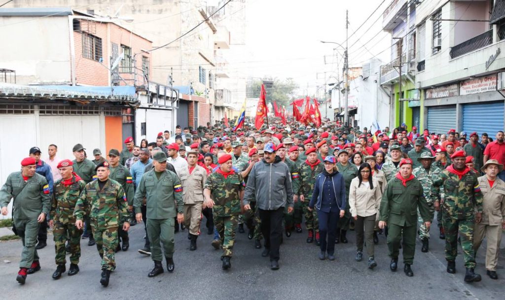 Венесуелският президент Николас Мадуро (в средата, в сиво яке) заедно с други ръководни държавни и военни дейци крачи заедно с представители на въоръжените сили и на народните милиции по улица в град Маракай. Снимка: EFE 