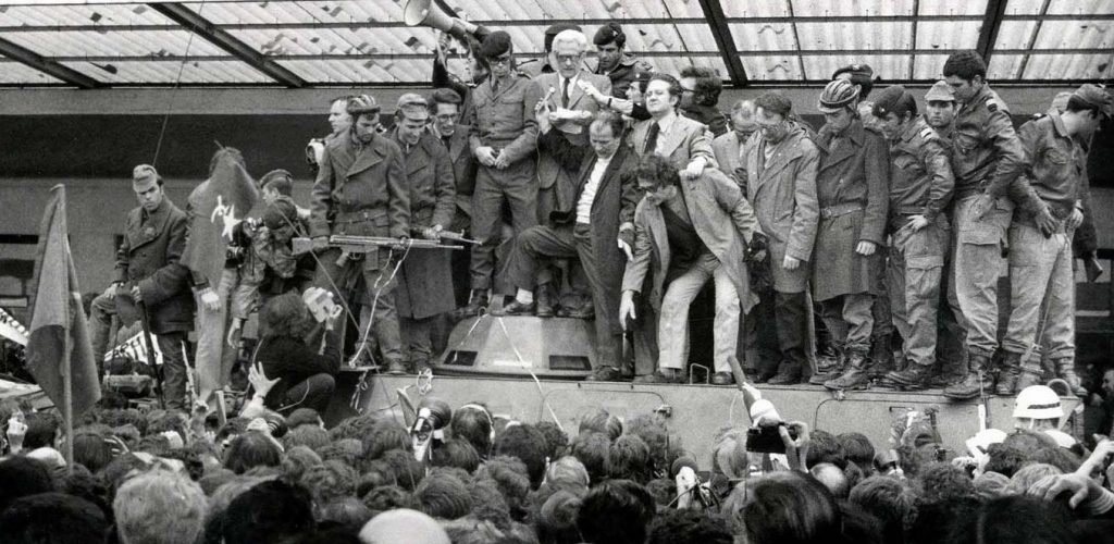 Алваро Кунял държи реч на гарата в Лисабон непосредствено след завръщането си от емиграция на 27 април 1974 г., покачен върху корпуса на танк. До него е Марио Соариш. Заобикалят ги бойци от Движението на капитаните. Снимка: geral forum