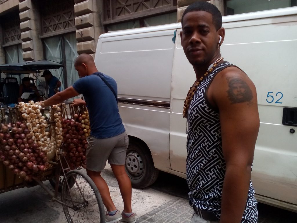Този млад продавач на лук изостана от приятеля си,тикащ количката, за да покаже домре пред обектива бицепса си татуирания портрет на Че. Снимка: Къдринка Къдринова