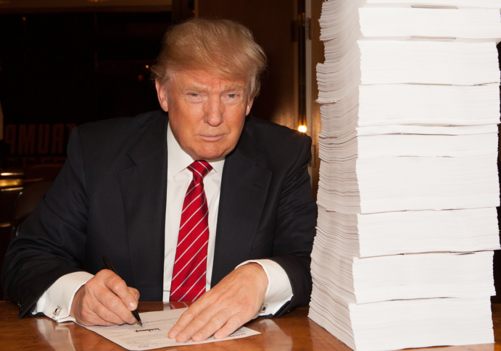 Тръмп подписва иронично данъчните си декларации, за които сега става ясно, че са пълни със съмнителни схеми за укриване на данъци.