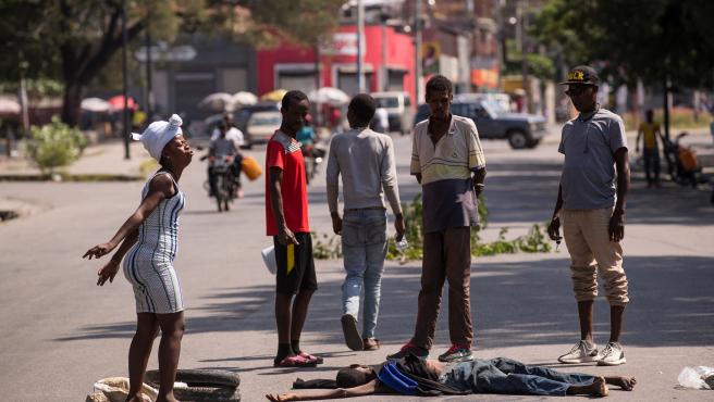 Труп на издъхнал от глад просяк остана да лежи часове на ред насред улицата пред президентския дворец в Порт-о-Пренс. Снимка: EFE