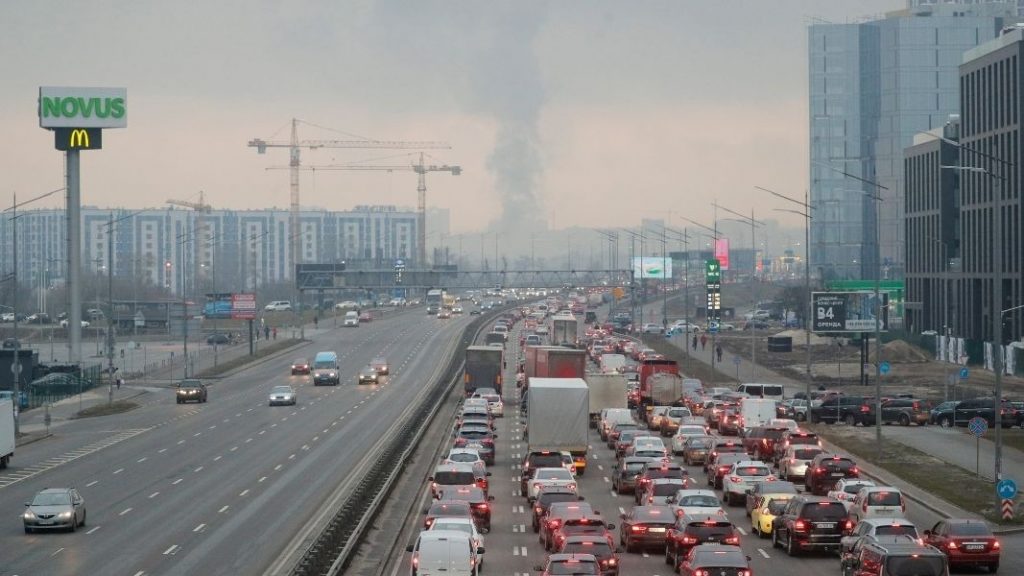 Задръстване в Киев заради колоните автомобили, които се опитват да напуснат столицата на фона на дим в небето от попадение на руски удар. Снимка: БГНЕС