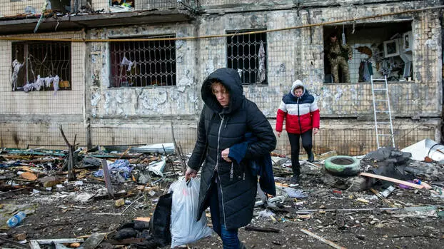 Жители напускат силно повредената жилищна сграда, ударена от руски снаряд в Киев, Украйна, 14 март 2022 г.  ZUMAPRESS.com | SOPA Images