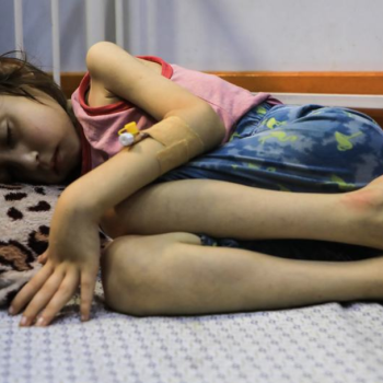 Дете, страдащо от недохранване, лежи на легло в болницата „Patient Society Hospital“ в град Газа. УНИЦЕФ/Мохамед Натил