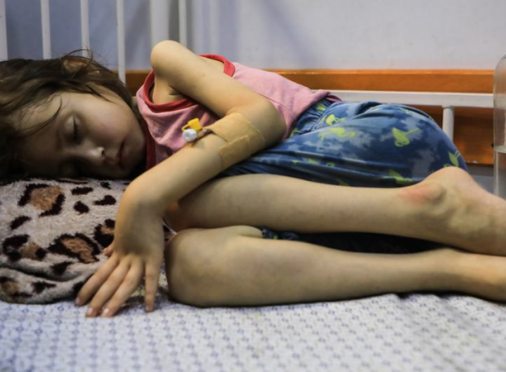 Дете, страдащо от недохранване, лежи на легло в болницата „Patient Society Hospital“ в град Газа. УНИЦЕФ/Мохамед Натил