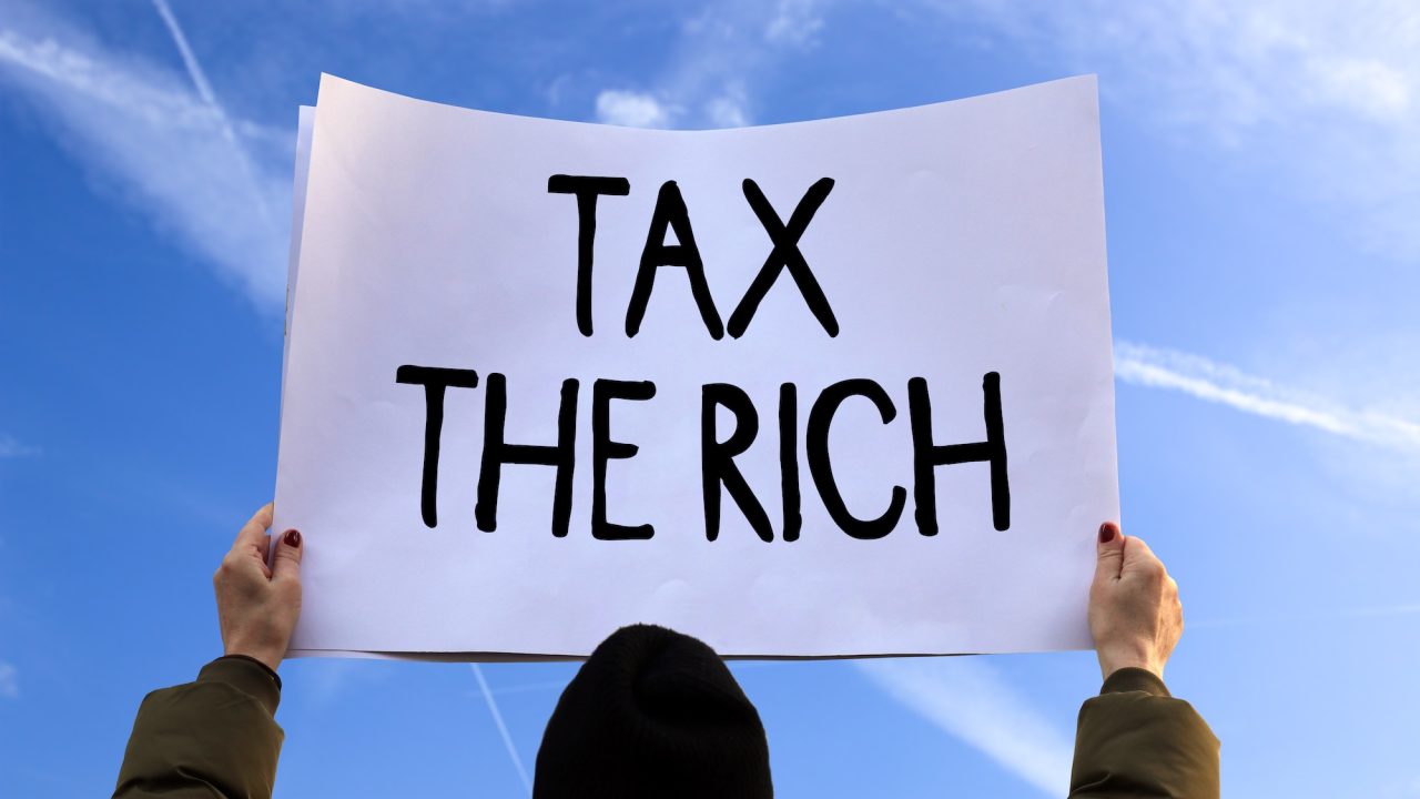 protest schild mit der aufschrift: tax the rich
