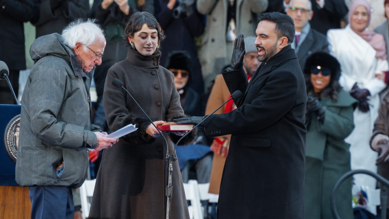 Момент от клетвата на Зохран Мамдани като кмет на Ню Йорк пред Бърни Сандърс. В средата е съпругата на Мамдани – Рама Дууажи. Снимка: Euronews