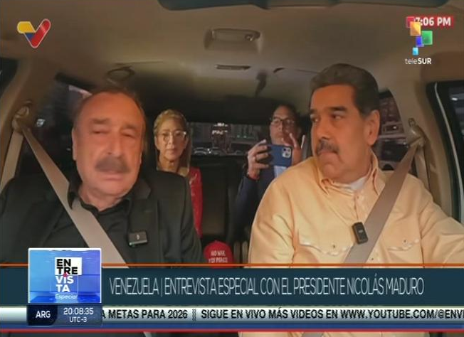 Николас Мадуро и Игнасио Рамоне по време на интервюто. На заден план са президентската съпруга Силия Флорес и един от вицепрезидентите – Фреди Няниес. Кадърът е от едновременно излъчване на репортаж за интервюто по венецуелската държавна телевизия VTV и телевизия „Телесур“
