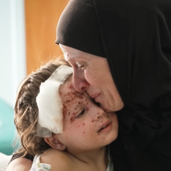 4-годишната Малика, която се лекува от рани от шрапнели, е утешавана от баба си Амина в болница в Бейрут. Майката на Малика е убита, когато се е опитвала да я предпази в първите часове на войната.