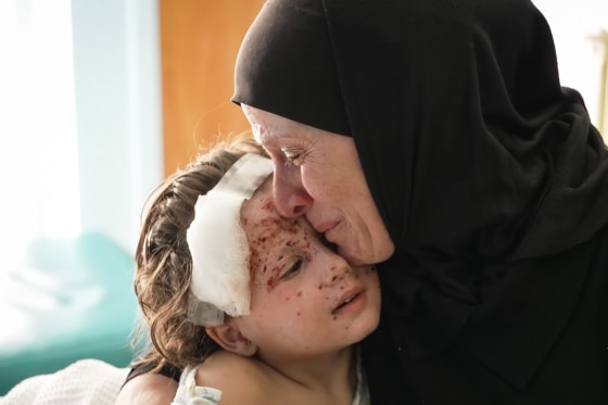 4-годишната Малика, която се лекува от рани от шрапнели, е утешавана от баба си Амина в болница в Бейрут. Майката на Малика е убита, когато се е опитвала да я предпази в първите часове на войната.